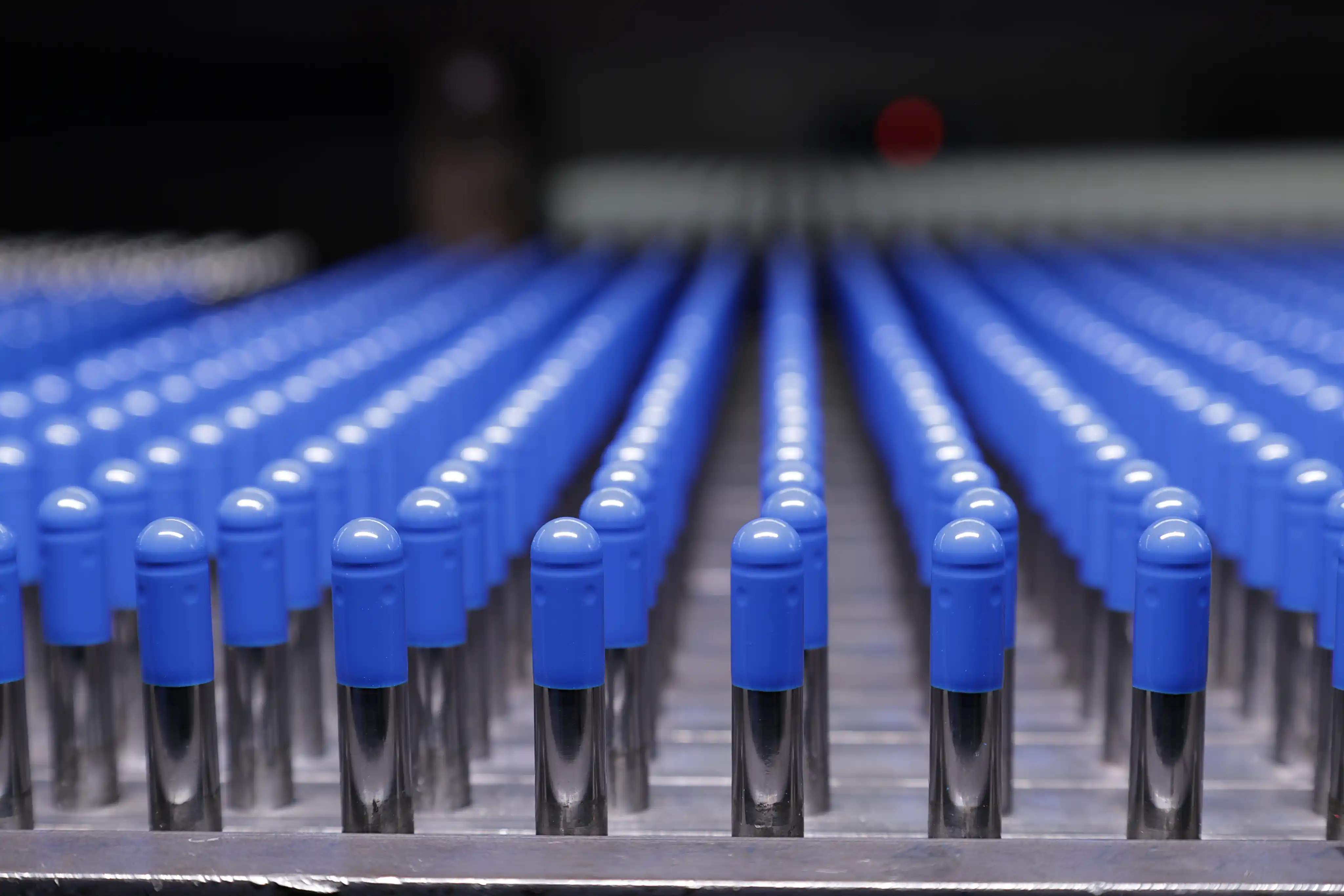 Freshly dipped red capsule shells on the production line