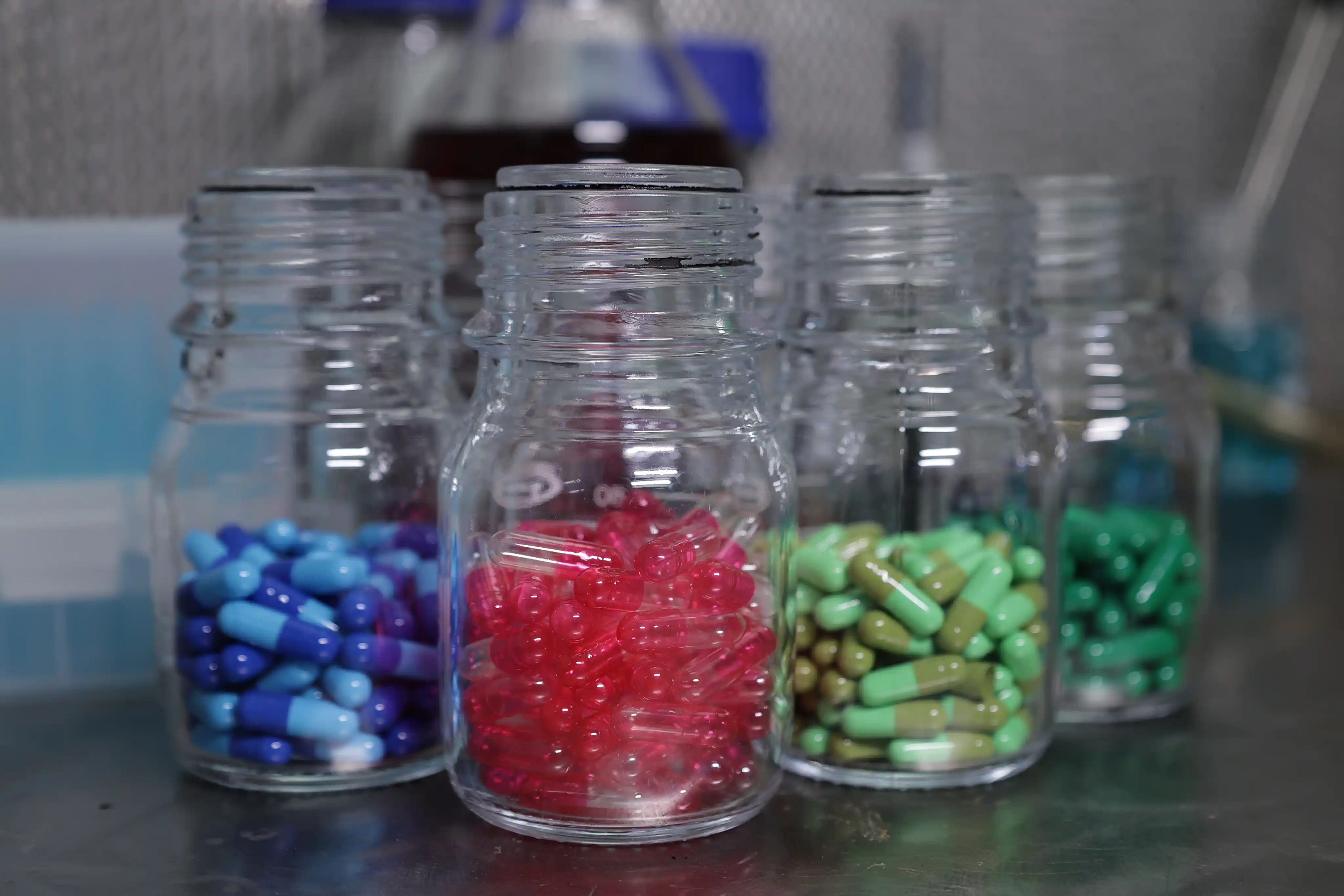 Glass jars of coloured capsule shells in controlled storage